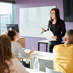 Student reading book in library wearing mask