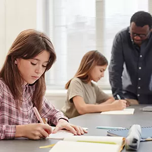 Student reading book in library wearing mask