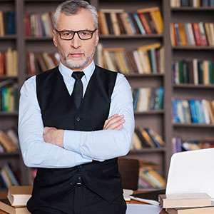 Student reading book in library wearing mask