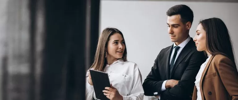 Business meeting with a man and woman discussing something on a tablet